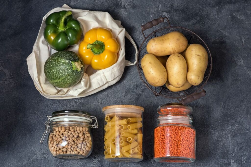 Präsentation verschiedener Produkte, von Gemüse bis hin zu wiederverwendbaren Gläsern mit Trockenprodukten, nach den Grundsätzen des abfallfreien Lebens