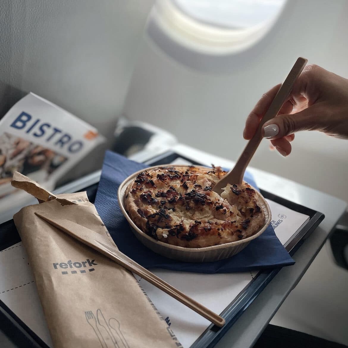 Refork cutlery on a food tray next to mashed potato pie. View from an airplane. 
