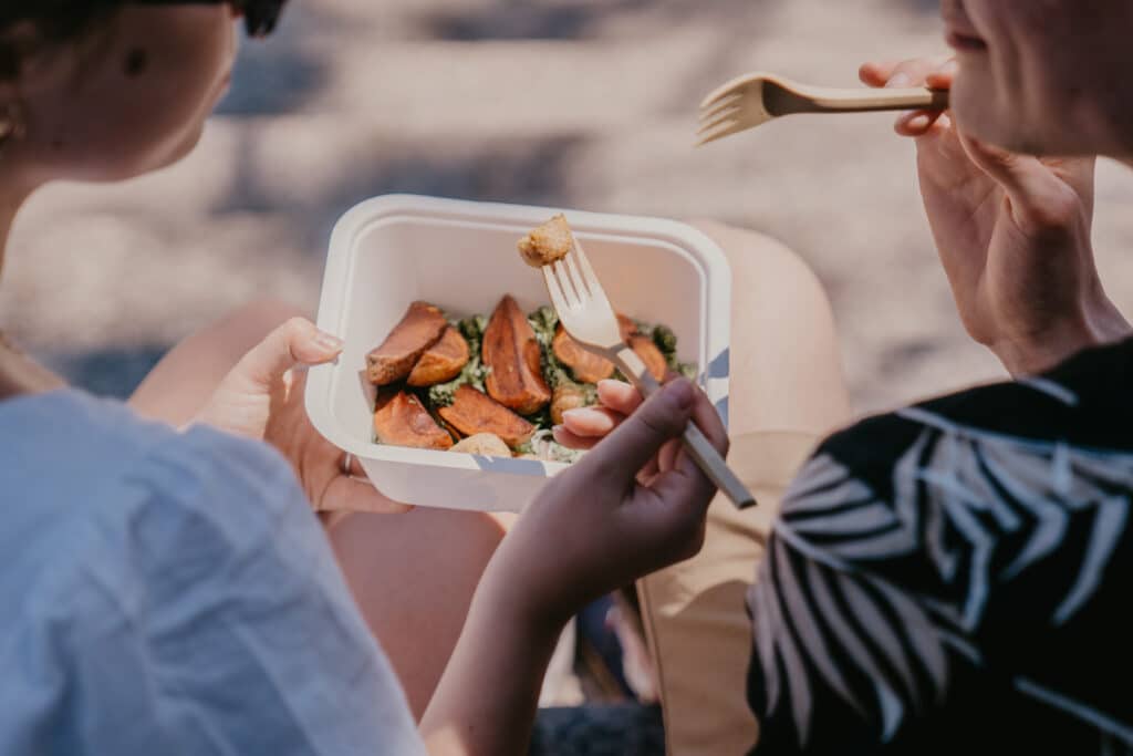 people eating with biodegradable cutlery.
